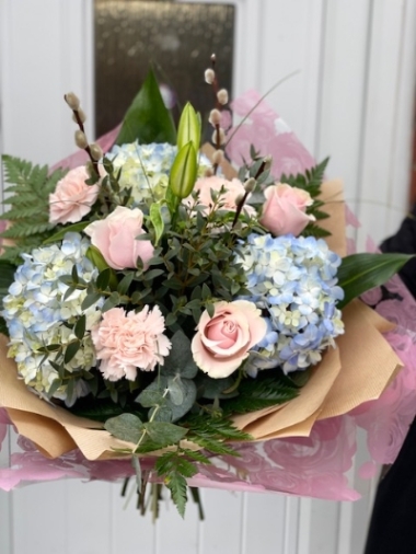 Beautiful hand tied arrangement of Hydrangeas, roses, coronations, Lilly and pussy willow with seasonal foliage